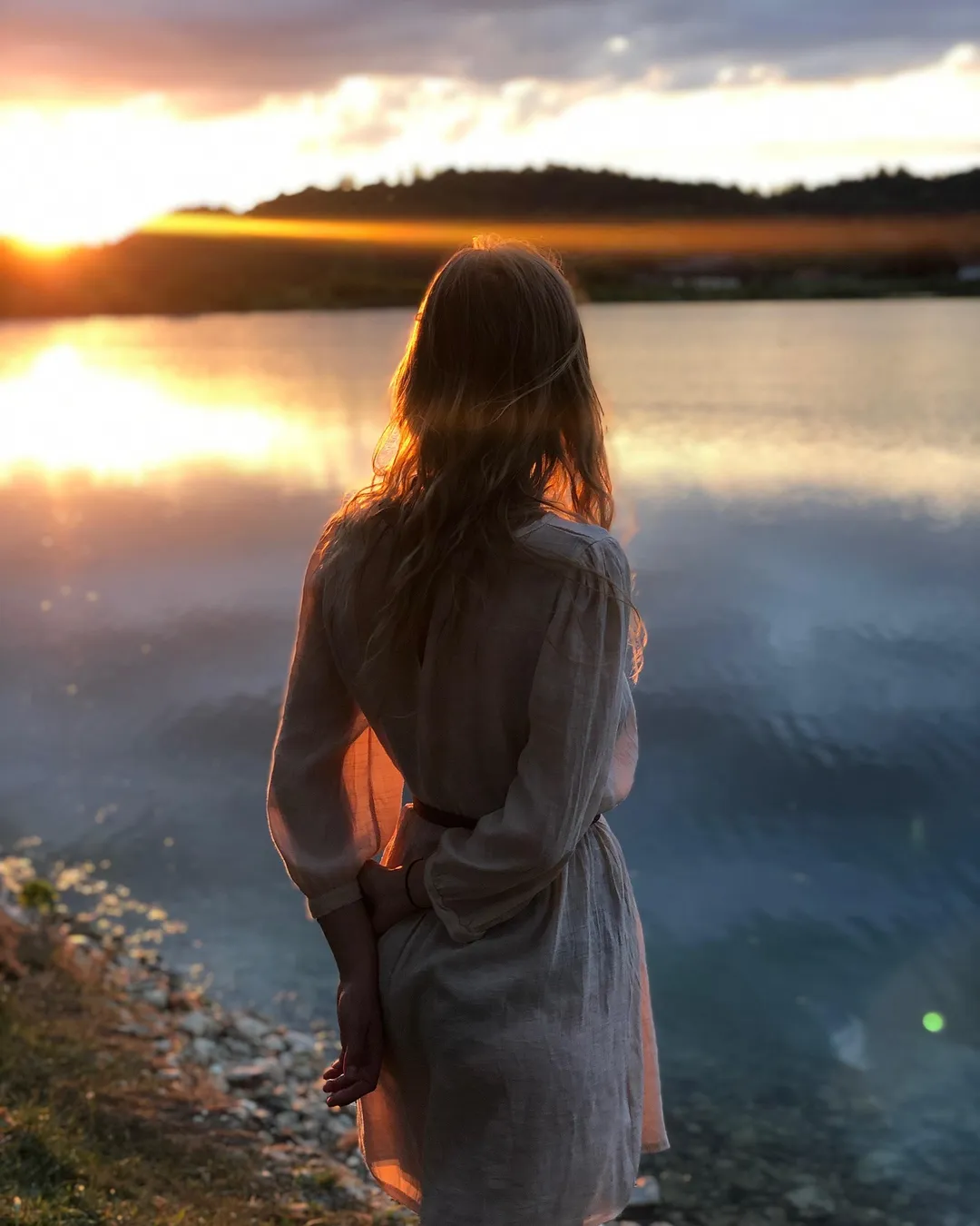 Example of a Facebook portrait feed post at 4:5, 1080 x 1350 pixels: a woman in a light dress standing by a lake at sunset